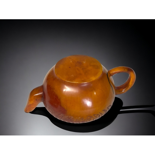 68 - A CHINESE CARVED AMBER TEAPOT.
Qing dynasty. 
Carved Tokens with script to body and lid. 
Impressed ... 