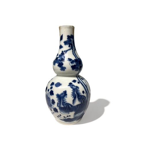 74 - A CHINESE BLUE & WHITE PORCELAIN DOUBLE GOURD VASE.
Qing dynasty.
Painted with numerous exotic birds... 