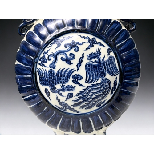 77 - A Chinese blue & white porcelain moon flask. Depicting double Phoenix amongst the clouds. Stylis... 