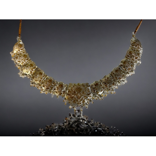 394 - A PERSIAN? WHITE & GILT METAL ENAMELLED CHOKER NECKLACE.
Stylised foliate design, with drop pearls &... 