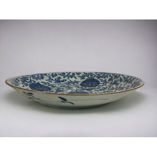 104 - A large Chinese porcelain blue & white charger. Qing dynasty, Kangxi period. Painted Lotus flowe... 