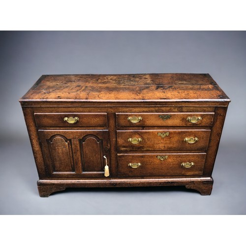 289 - AN early 18th century Oak side cupboard.
Plank top above four drawers and arched door. On bracket fe... 