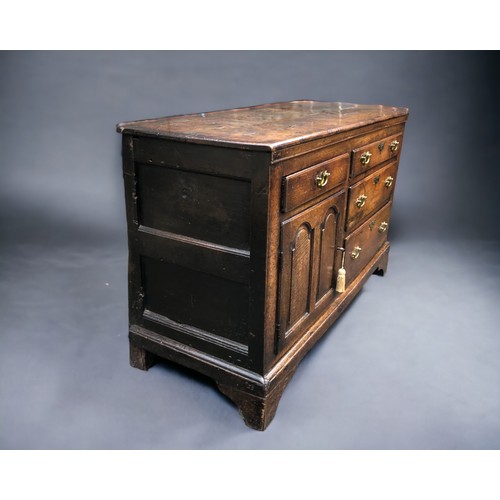 289 - AN early 18th century Oak side cupboard.
Plank top above four drawers and arched door. On bracket fe... 