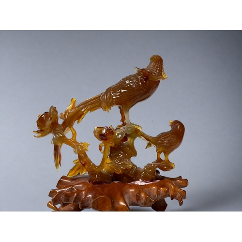 144 - A Chinese carved Carnelian 'Birds of Paradise' sculpture.
20th Century. on carved wooden base.
Toget... 