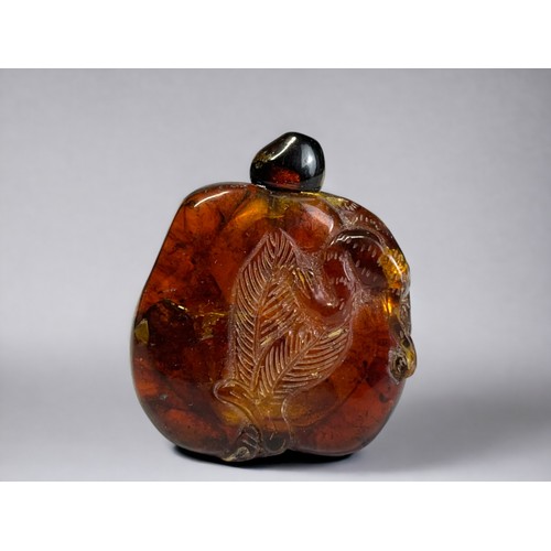 156B - Chinese carved amber snuff bottle.
Qing dynasty.
Carved with leaf design and a monkey over left shou... 