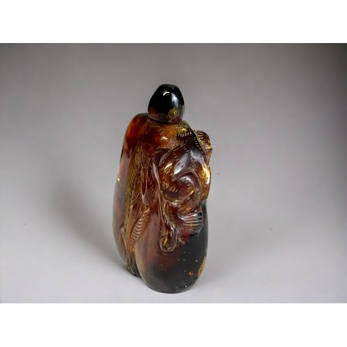 156B - Chinese carved amber snuff bottle.
Qing dynasty.
Carved with leaf design and a monkey over left shou... 