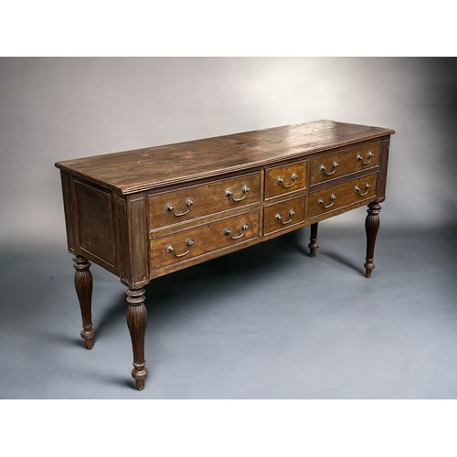 114 - A George III long Oak dresser base. With planked top and reeded legs. Two central drawers pair with ... 