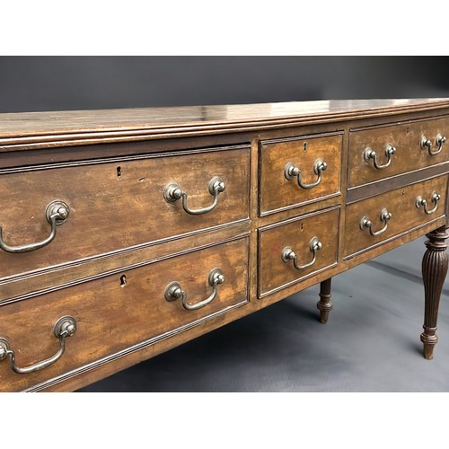 114 - A George III long Oak dresser base. With planked top and reeded legs. Two central drawers pair with ... 