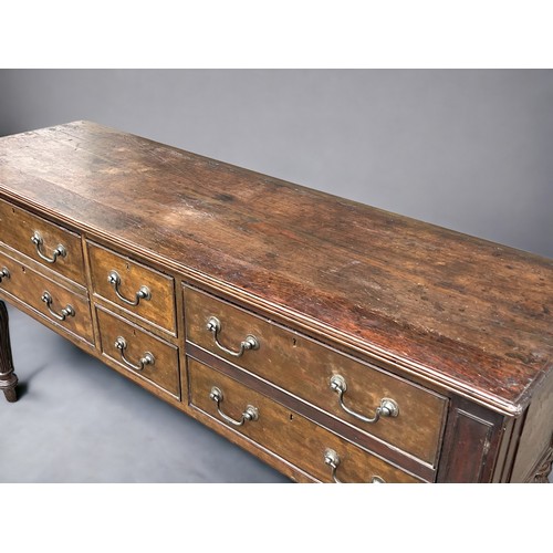 114 - A George III long Oak dresser base. With planked top and reeded legs. Two central drawers pair with ... 