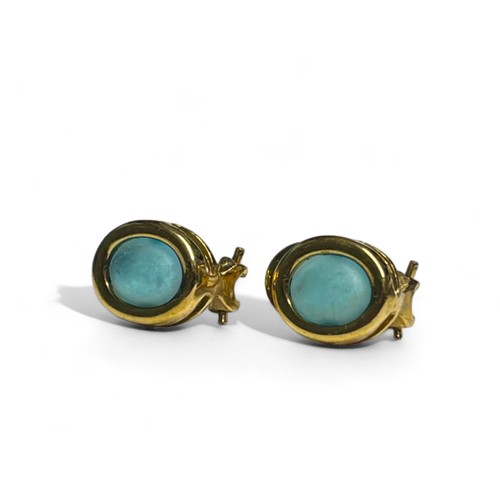 518 - A pair of yellow metal & blue cabochon stone set earrings.