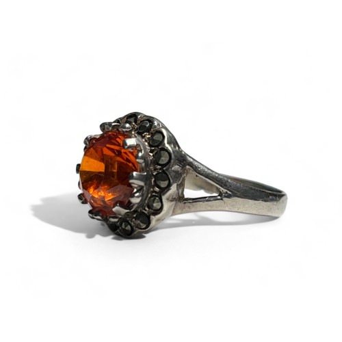 519 - A silver, Marcasite and orange stone set ladies ring. Stamped S925.