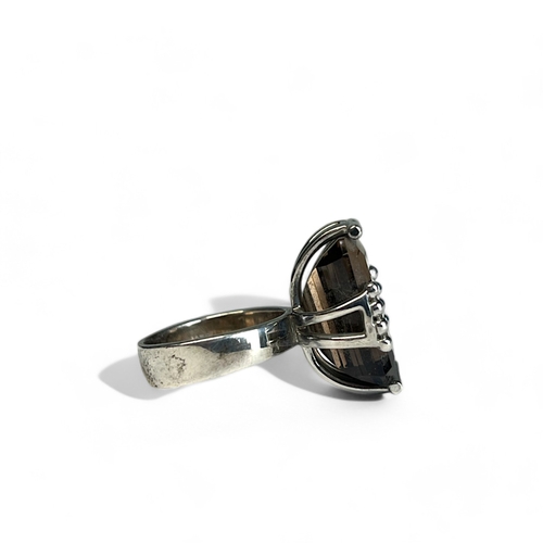 520 - A large sterling silver ladies ring.Set with a very large coloured stone, probably smoky quartz. Siz... 