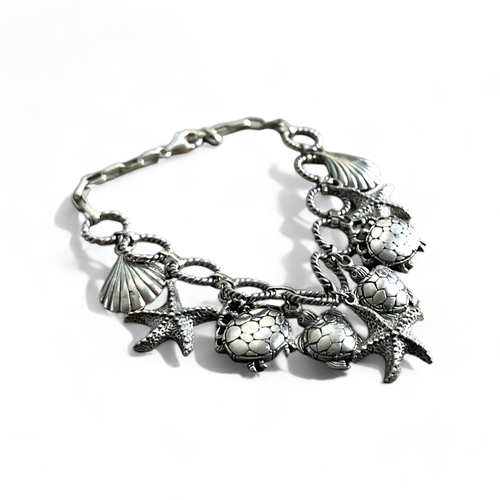 524 - A Sterling silver 'Sea life' charm bracelet.Stamped 925.Fitted with shell, stars, crabs and Turtle c... 