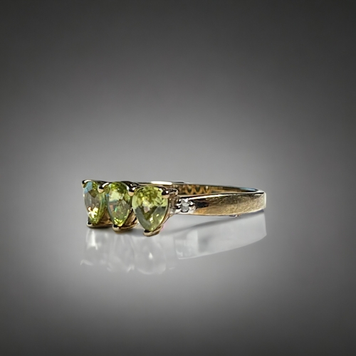 527 - A 9ct Gold and peridot ladies ring.Set with three pear shaped Peridot's and small accent diamonds to... 