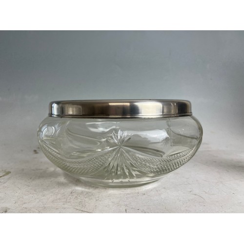 254 - A sterling silver rimed cut glass fruit bowl, together with silver collar scene bottle.Full hallmark... 