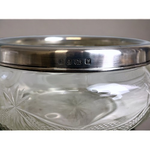 254 - A sterling silver rimed cut glass fruit bowl, together with silver collar scene bottle.Full hallmark... 