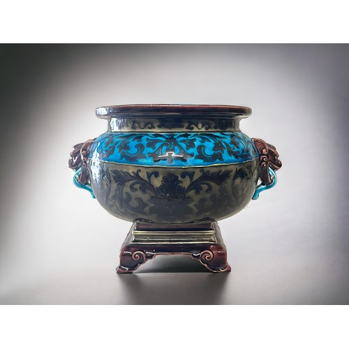 385 - A Majolica Jardiniere / plant pot.In the Oriental taste, with stylised foliate motifs and twin drago... 