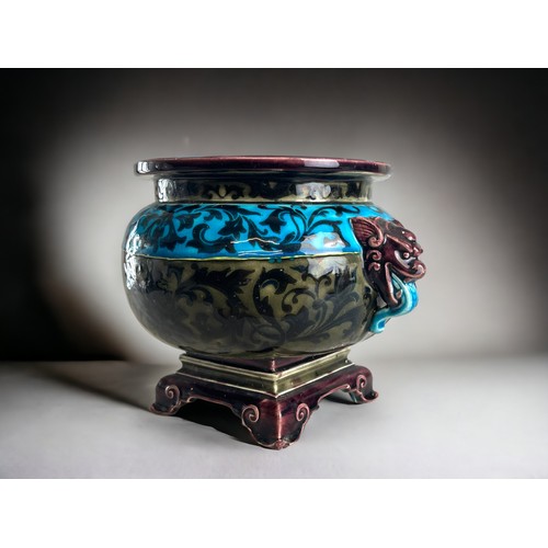 385 - A Majolica Jardiniere / plant pot.In the Oriental taste, with stylised foliate motifs and twin drago... 