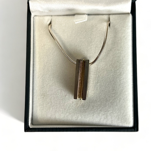 545 - A silver & yellow metal bar necklace. Stamped 