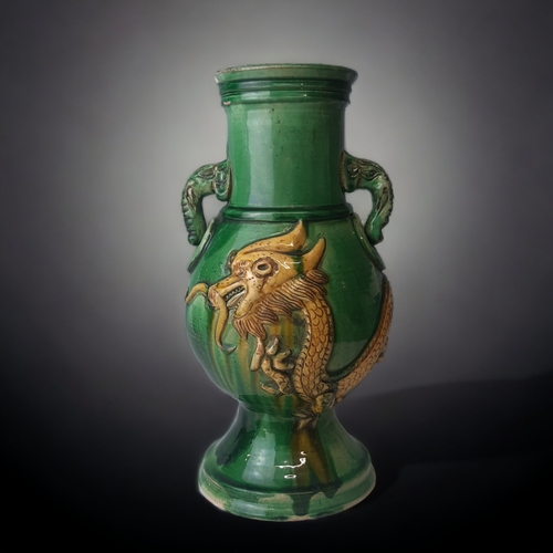 100 - A LARGE CHINESE SANCAI GLAZED VASE.
RELIEF DECORATED WITH A 5-CLAW DRAGON AND TWIN ELEPHANT HANDLES.... 