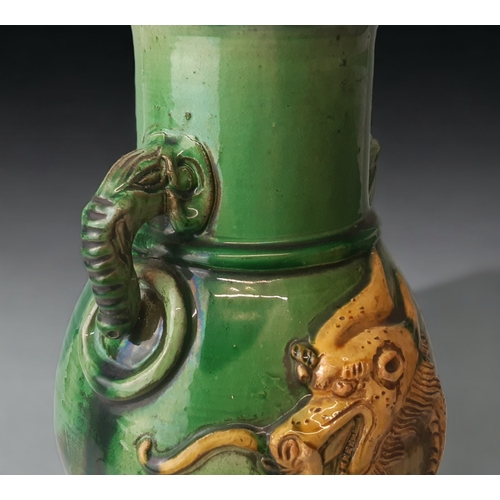 100 - A LARGE CHINESE SANCAI GLAZED VASE.
RELIEF DECORATED WITH A 5-CLAW DRAGON AND TWIN ELEPHANT HANDLES.... 