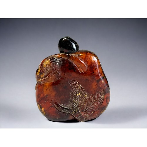 104 - Chinese carved amber snuff bottle.
Qing dynasty.
Carved with leaf design and a monkey over left shou... 