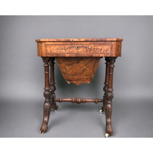 128 - A VICTORIAN BURR WALNUT WORK TABLE. Carved legs raised on original casters. Joined by turned wood st... 