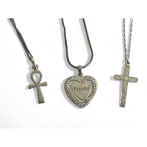 405 - Three silver pendant necklaces. Including a Cross, Egyptian Ankh and 'Friend' heart pendant.