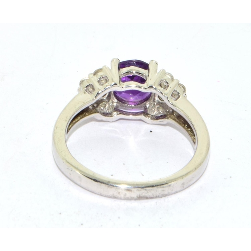 435 - 925 silver ladies Amethyst set with stone decoration to the side ring size O