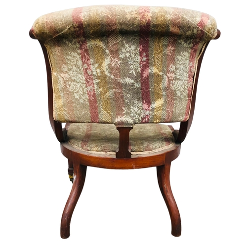 28 - Late 19thC spoonback upholstered low chair.  Mahogany framed with brass casters.