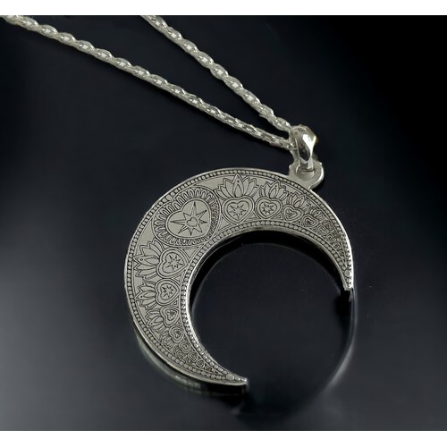 223 - A silver Cart Gore Crescent moon shaped pendant. On a silver chain.