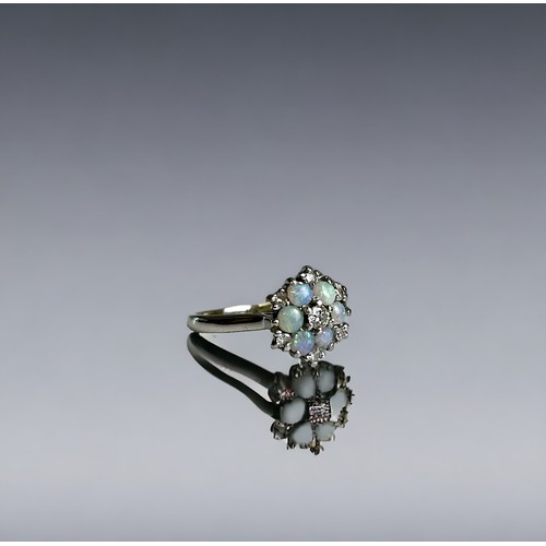 502 - An 18ct white gold, Opal and Diamond ring.Flower design, set with six opal's and central round cut d... 