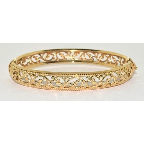 231 - 9ct gold open work bangle with spring closed mechanism, 9.3g