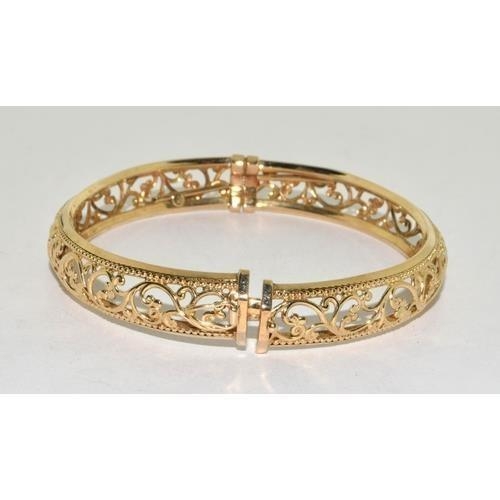 231 - 9ct gold open work bangle with spring closed mechanism, 9.3g