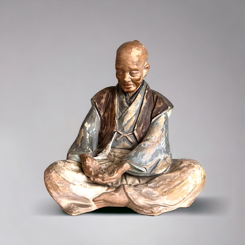 60 - A Japanese Hakata doll.Depicting a smiling old man (Nikoniko). Unglazed & and painted.Height - 2... 