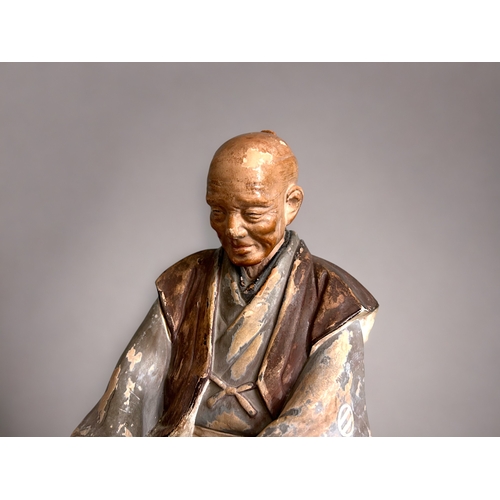 60 - A Japanese Hakata doll.Depicting a smiling old man (Nikoniko). Unglazed & and painted.Height - 2... 