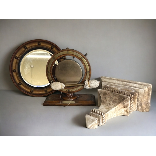 511 - A 19th century gilt porthole mirror, together with a Victorian dinner gong and painted wood corbel.