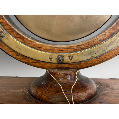 511 - A 19th century gilt porthole mirror, together with a Victorian dinner gong and painted wood corbel.