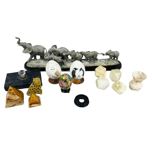 23 - A figural group of elephants together with porcelain eggs, and various paperweights.