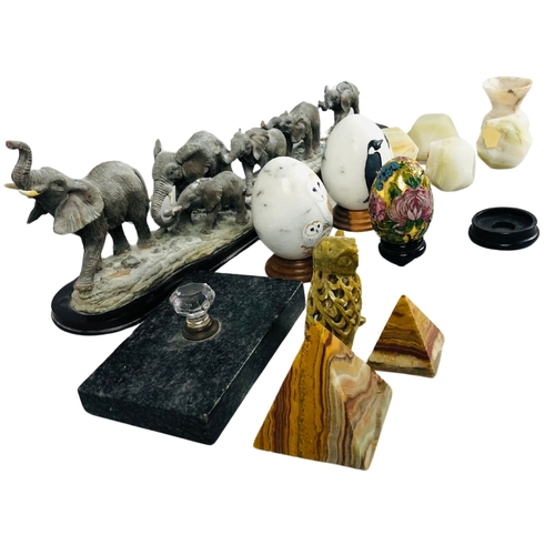 23 - A figural group of elephants together with porcelain eggs, and various paperweights.