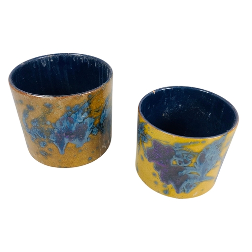 119 - Pair of studio pottery pots with a mustard yellow base and blue/purple splash decoration