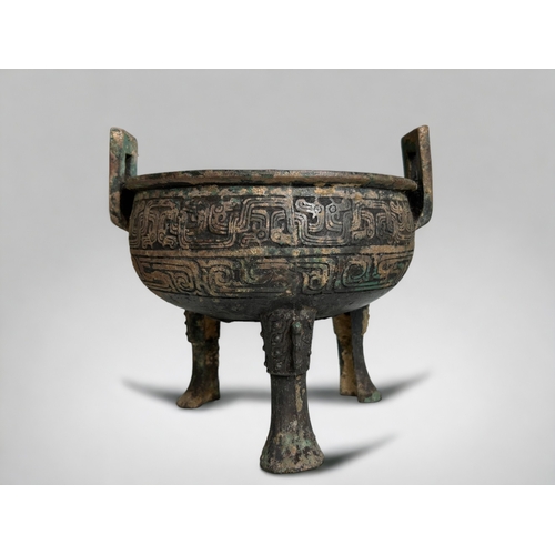 109 - A Chinese bronze ritual ding.Round body raised on tripod legs and twin handled. scrolling Leiwen des... 