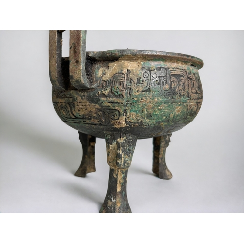 109 - A Chinese bronze ritual ding.Round body raised on tripod legs and twin handled. scrolling Leiwen des... 