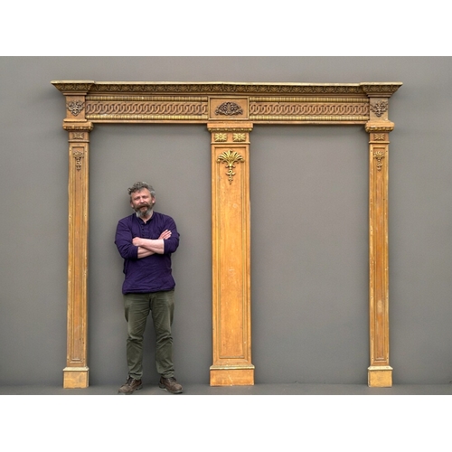 753 - A very large carved wood twin-door surround.Two outer columns with larger central divider. The heade... 