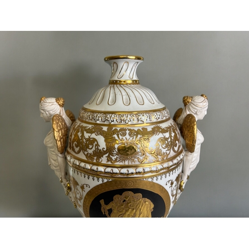 766 - A large Dresden style porcelain vase.With twin  bisque winged maiden handles. Classical black & ... 