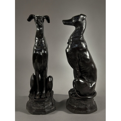 789 - A large pair of Art Deco Style bronze greyhounds.20th century.Seated pose, raised on foliate design ... 