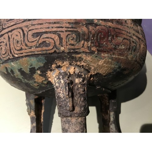 109 - A Chinese bronze ritual ding.Round body raised on tripod legs and twin handled. scrolling Leiwen des... 