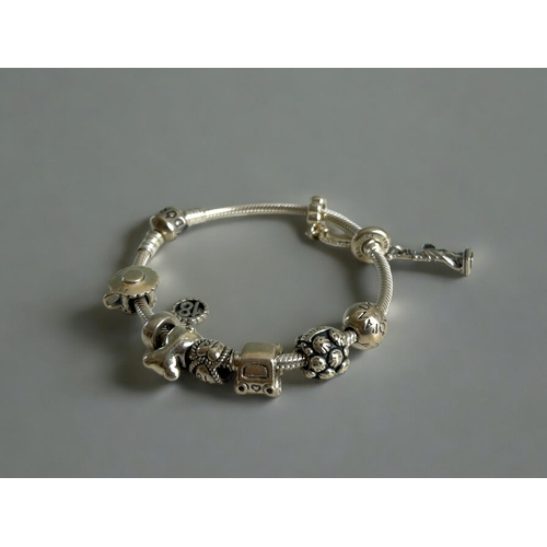 430 - A silver Pandora charm bracelet, with 9 charms. Together with leather & silver charms choker.