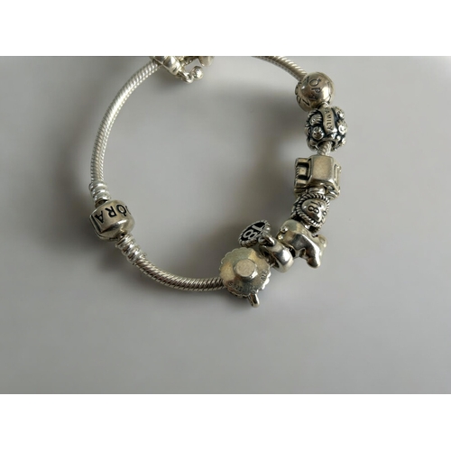 430 - A silver Pandora charm bracelet, with 9 charms. Together with leather & silver charms choker.