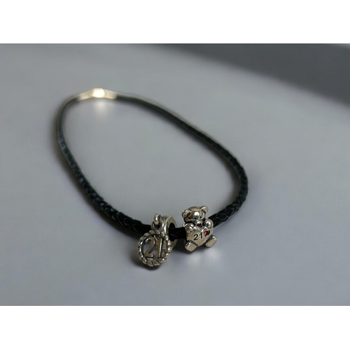 430 - A silver Pandora charm bracelet, with 9 charms. Together with leather & silver charms choker.